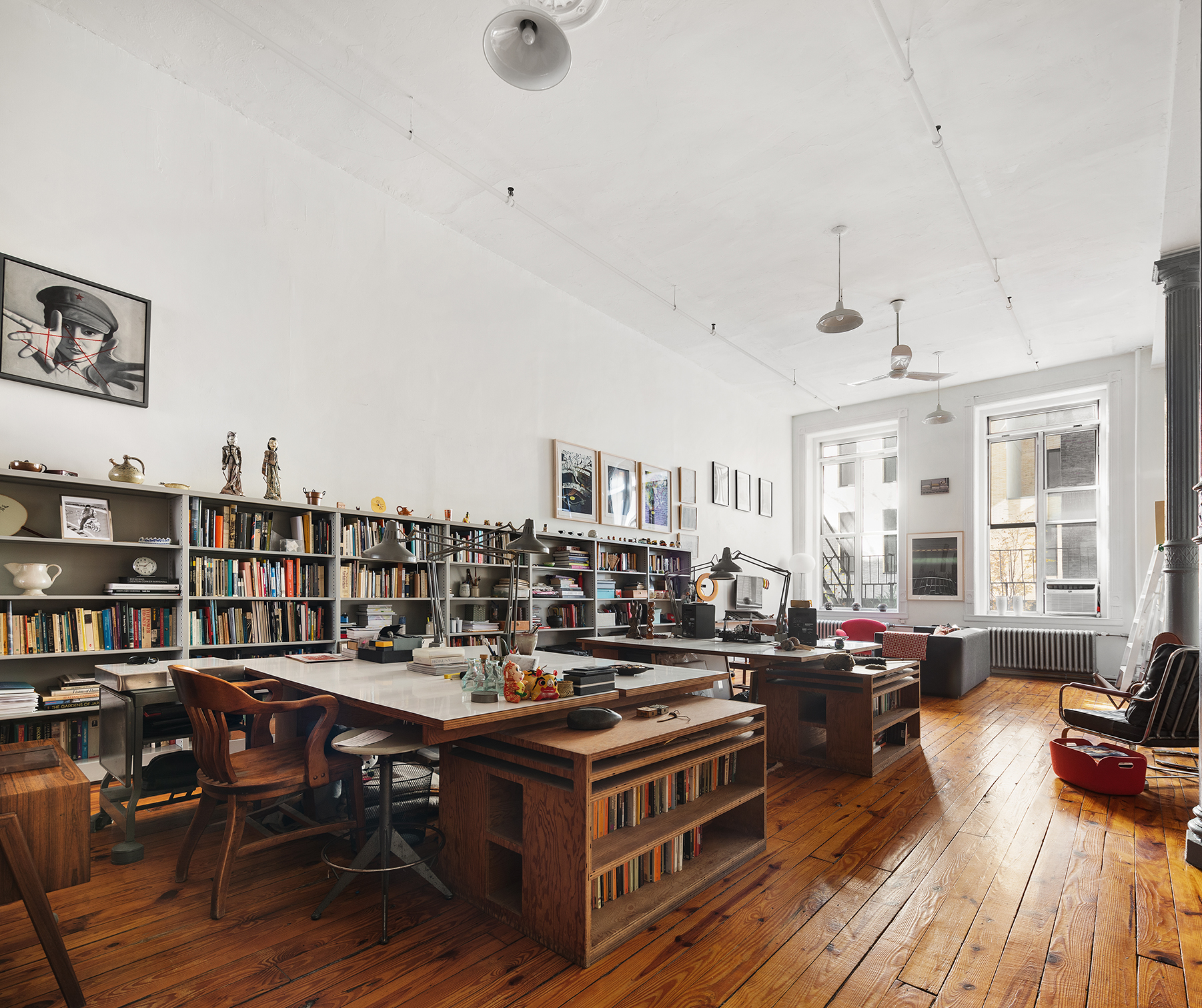 135 Greene Street, Unit 2N Manhattan, NY 10012 - Photo 8 of 13 a living room with furniture a rug and a book shelf
