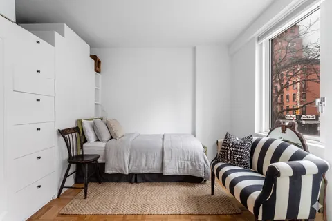 a bedroom with a bed and a large window