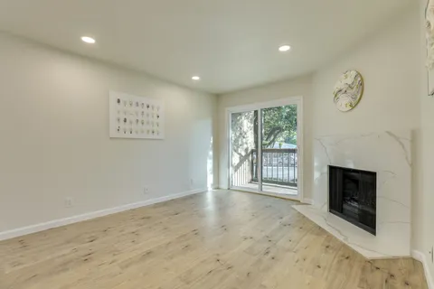 a view of an empty room with a fireplace and a window