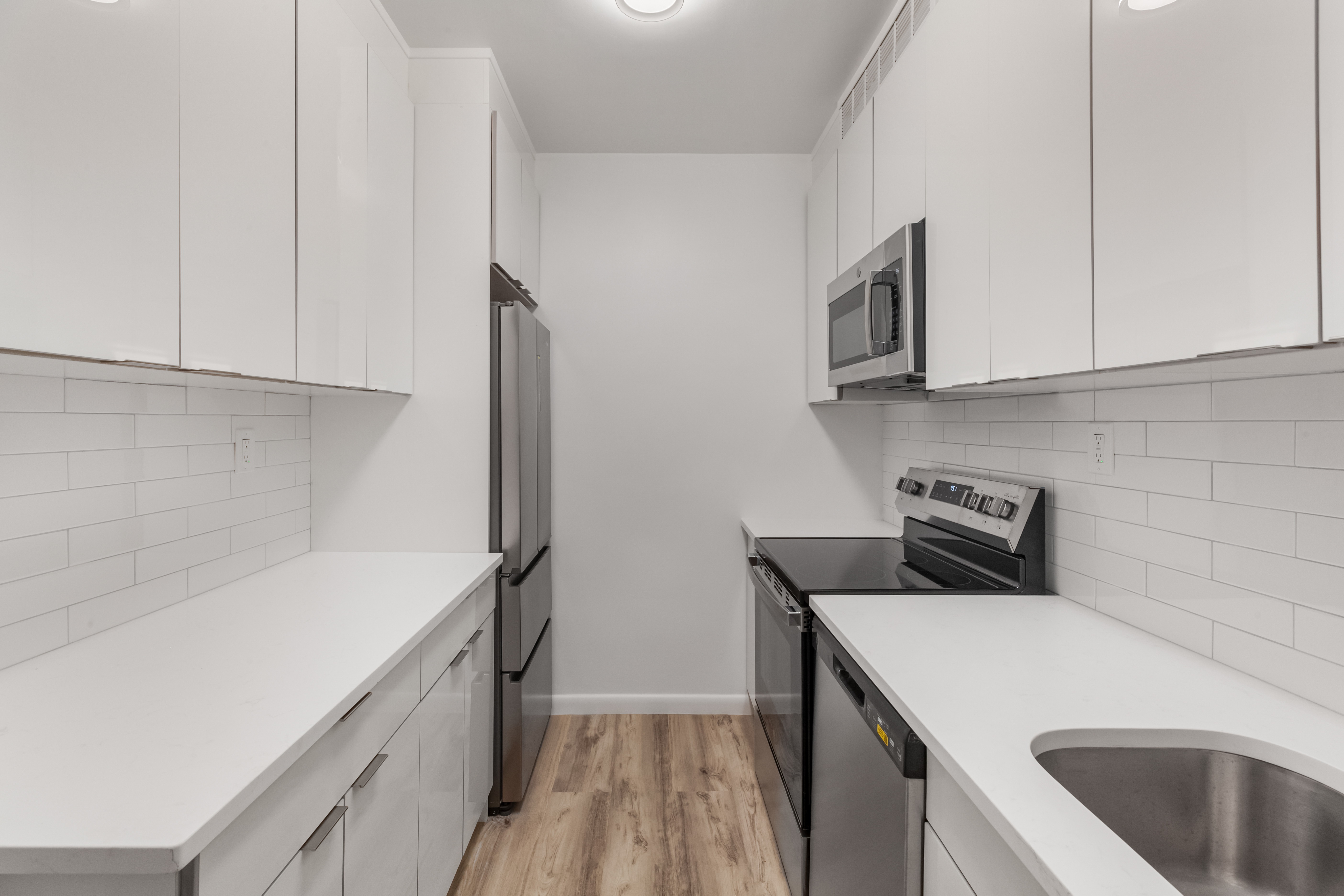 175 East 62nd Street, Unit 10B Manhattan, NY 10065 - Photo 5 of 12 a kitchen with a sink and a refrigerator