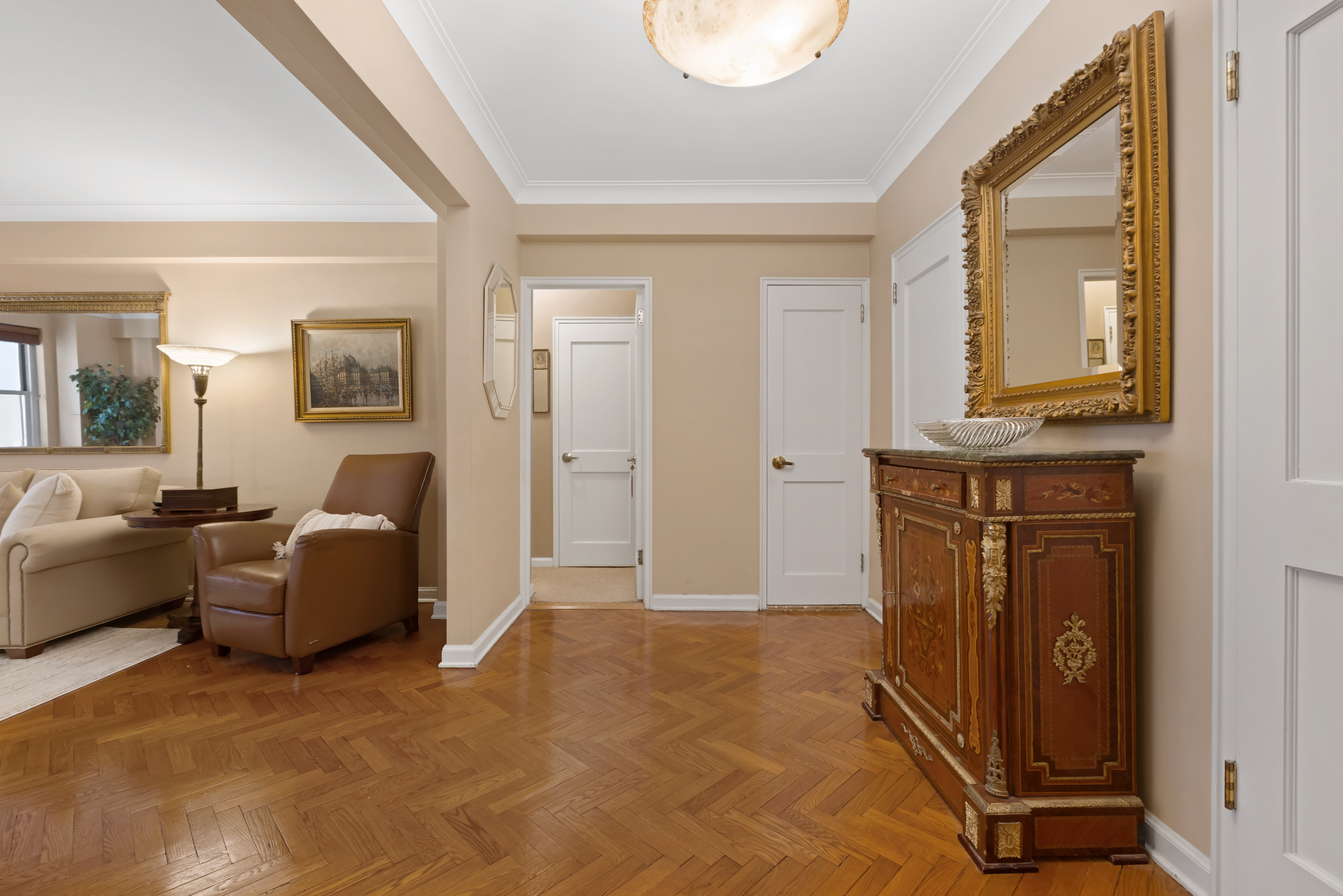 710 Park Avenue, Unit 5F Manhattan, NY 10021 - Photo 4 of 11 a living room with furniture a mirror and a window