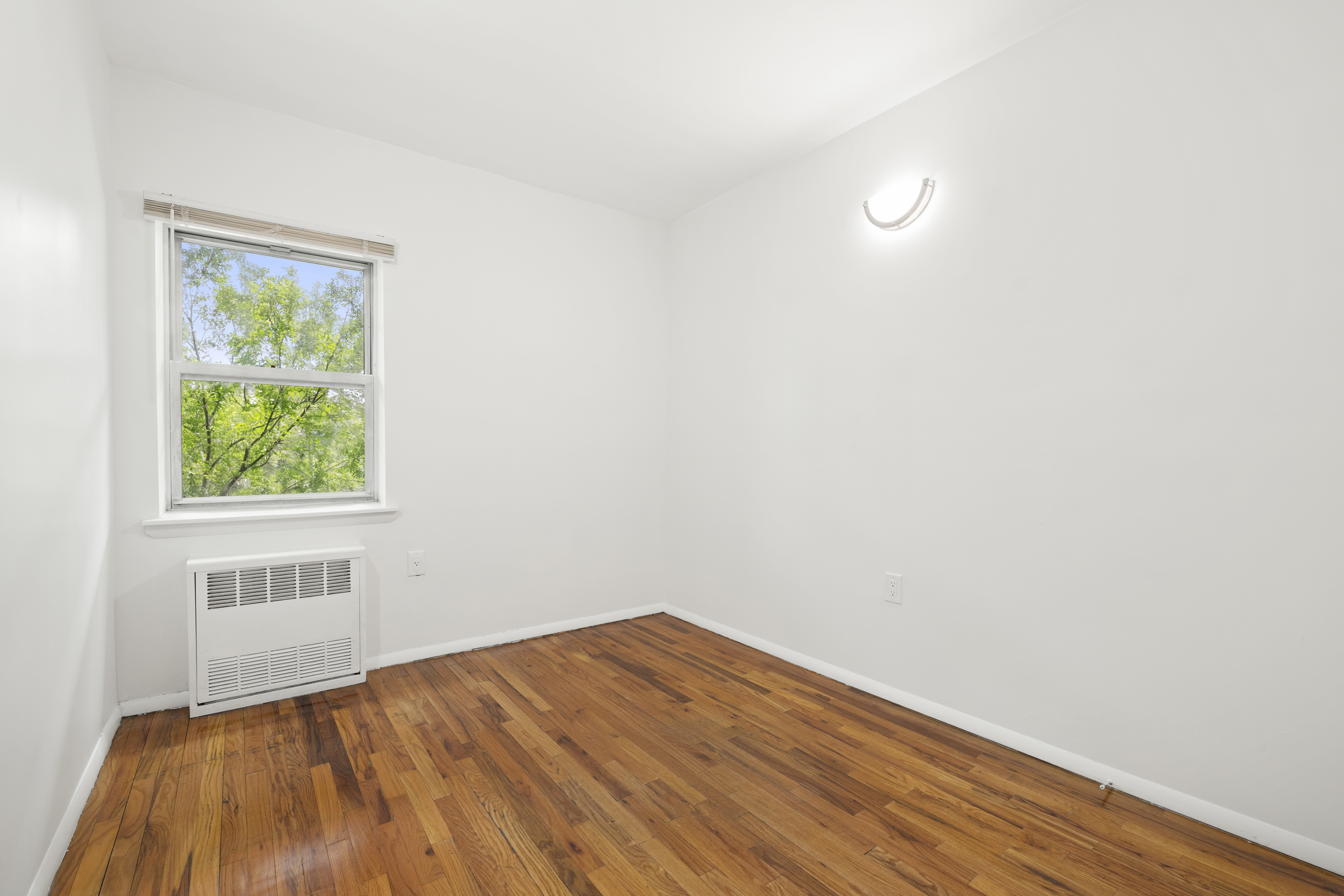1240 Bedford Avenue, Unit 3H Brooklyn, NY 11216 - Photo 9 of 12 a view of empty room with wooden floor and fan