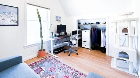 a view of a workspace with furniture and a window