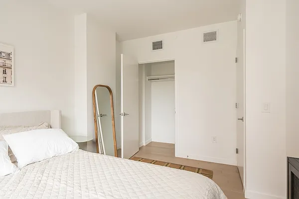 975 Nostrand Avenue, Unit 632 Brooklyn, NY 11225 - Photo 5 of 14 a bedroom with a bed and a mirror