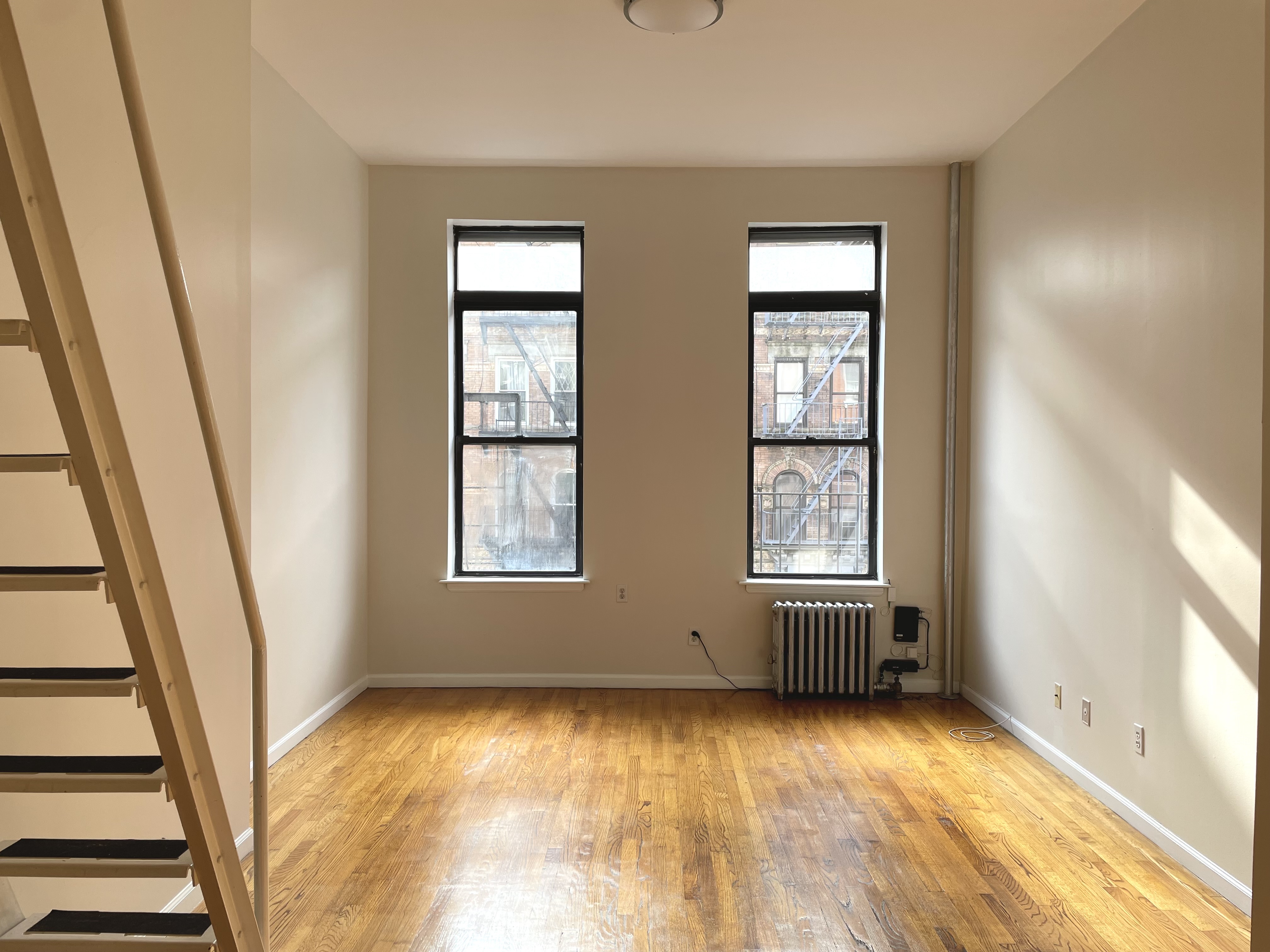 95 St Marks Place, Unit 6 Manhattan, NY 10009 - Photo 6 of 14 an empty room with windows