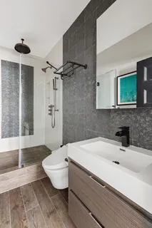 a bathroom with a sink a toilet and shower