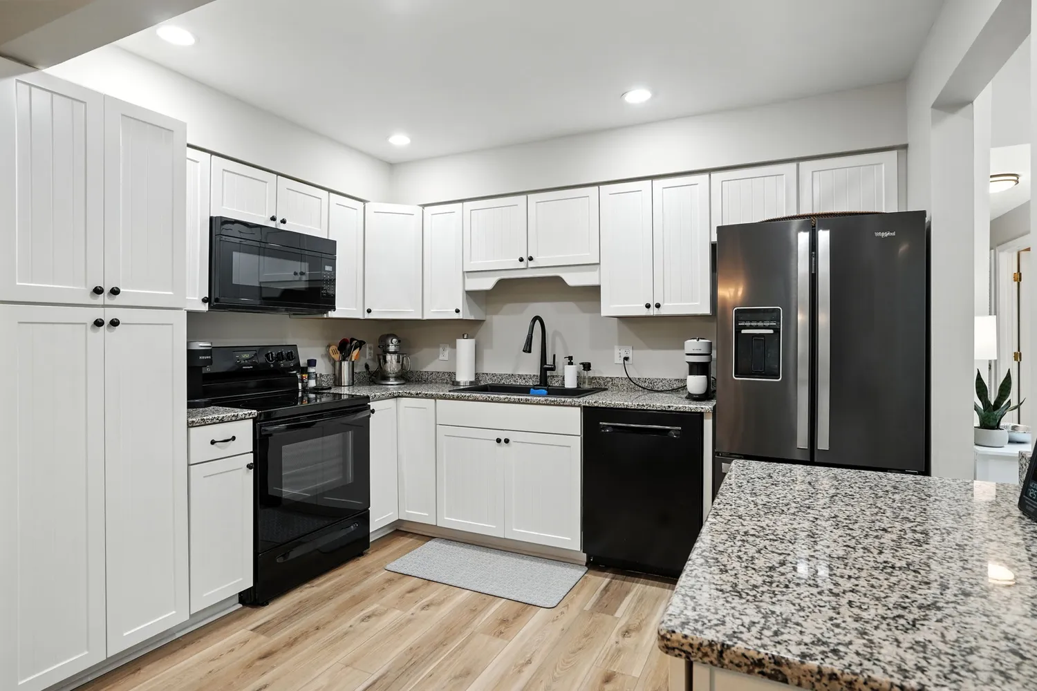 a kitchen with granite countertop a refrigerator stove top oven and sink
