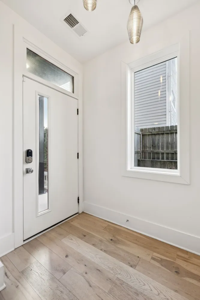 an empty room with wooden floor and windows
