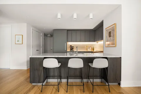 a kitchen with granite countertop a dining table chairs and wooden floor
