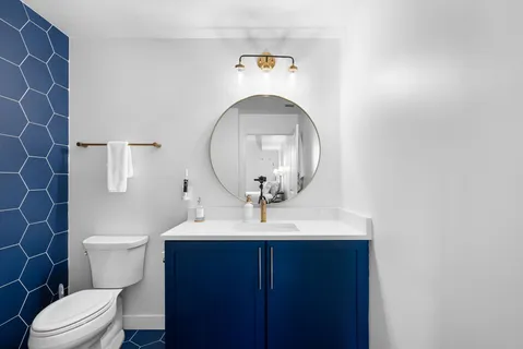 a bathroom with a sink a toilet and a mirror