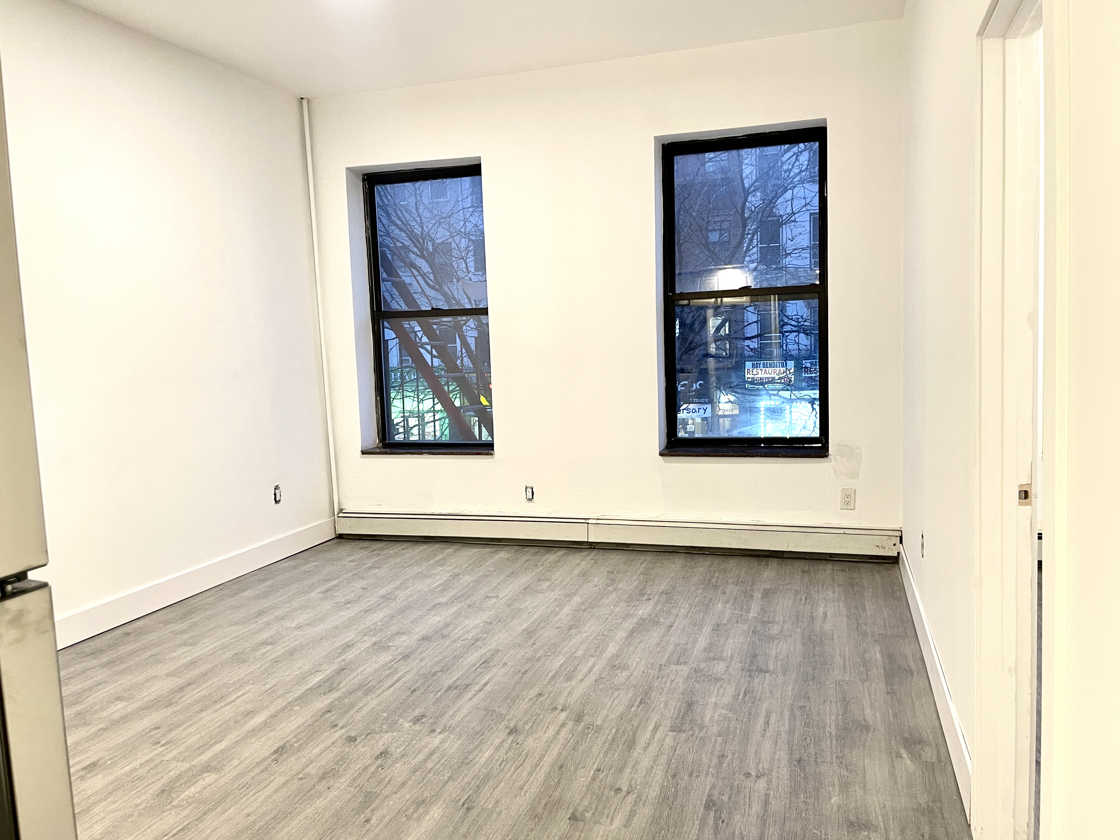 1999 3rd Avenue, Unit 1 Manhattan, NY 10029 - Photo 13 of 23 a view of an empty room and wooden floor