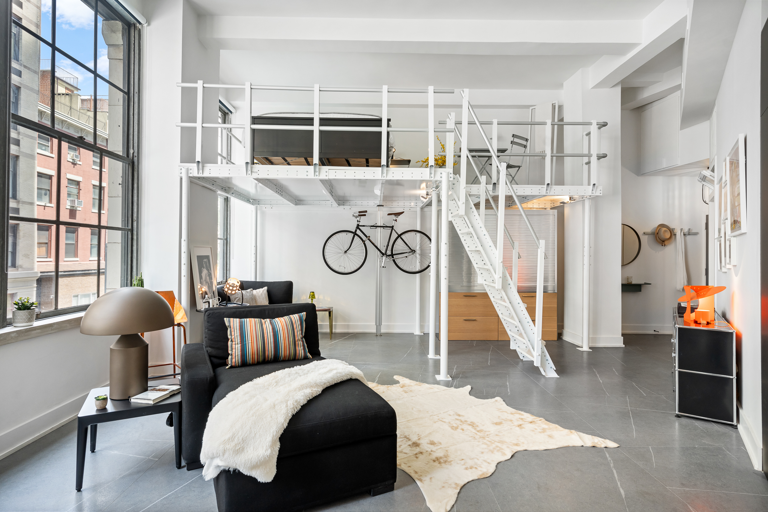 a bedroom with furniture and a large window