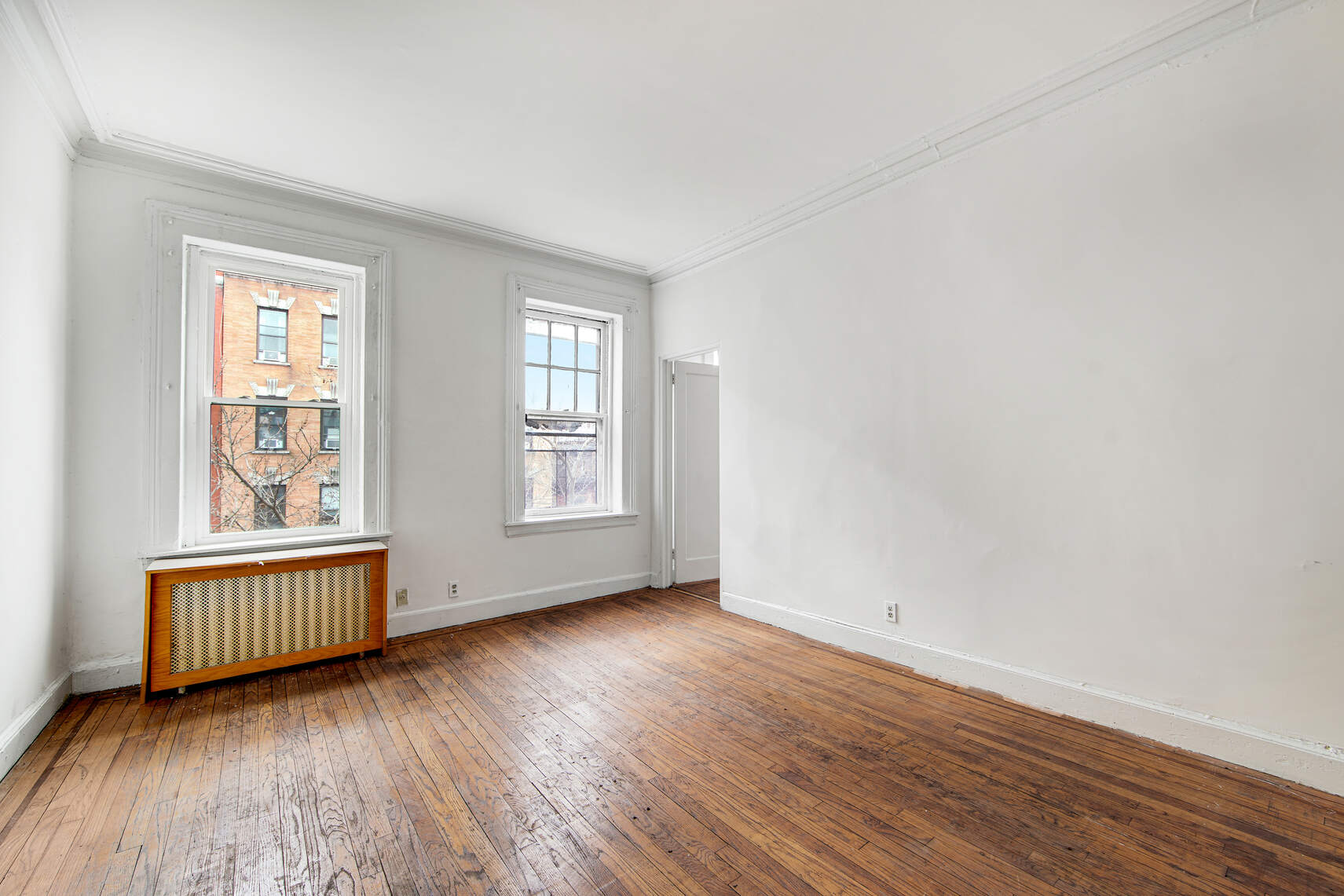 337 East 18th Street Manhattan, NY 10003 - Photo 10 of 16 an empty room with wooden floor and windows