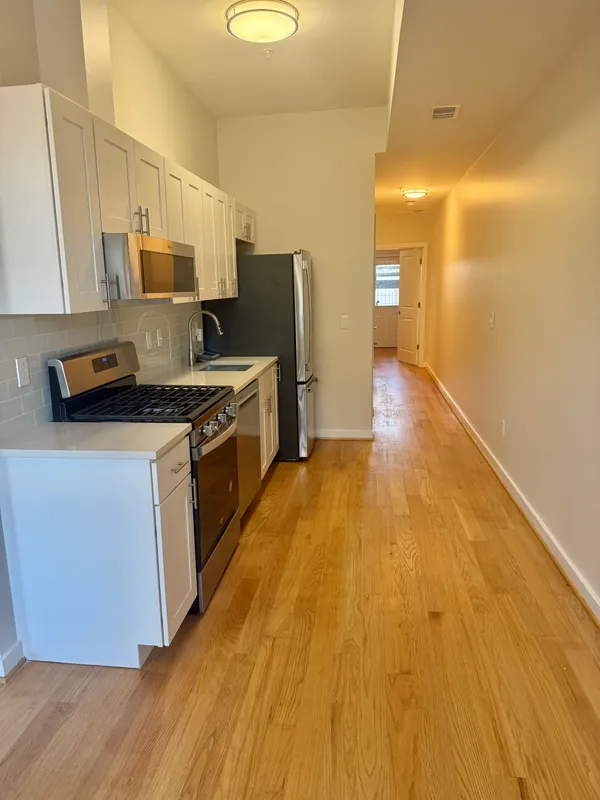 a kitchen with stainless steel appliances a stove refrigerator sink and microwave