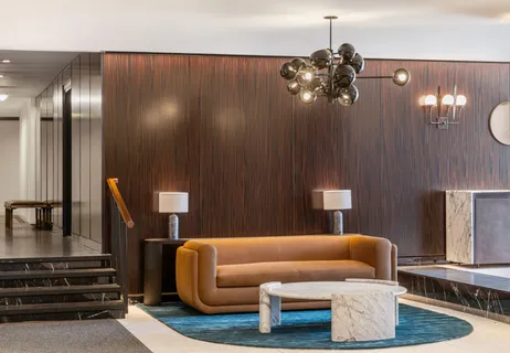 a living room with furniture flowerpot and a chandelier