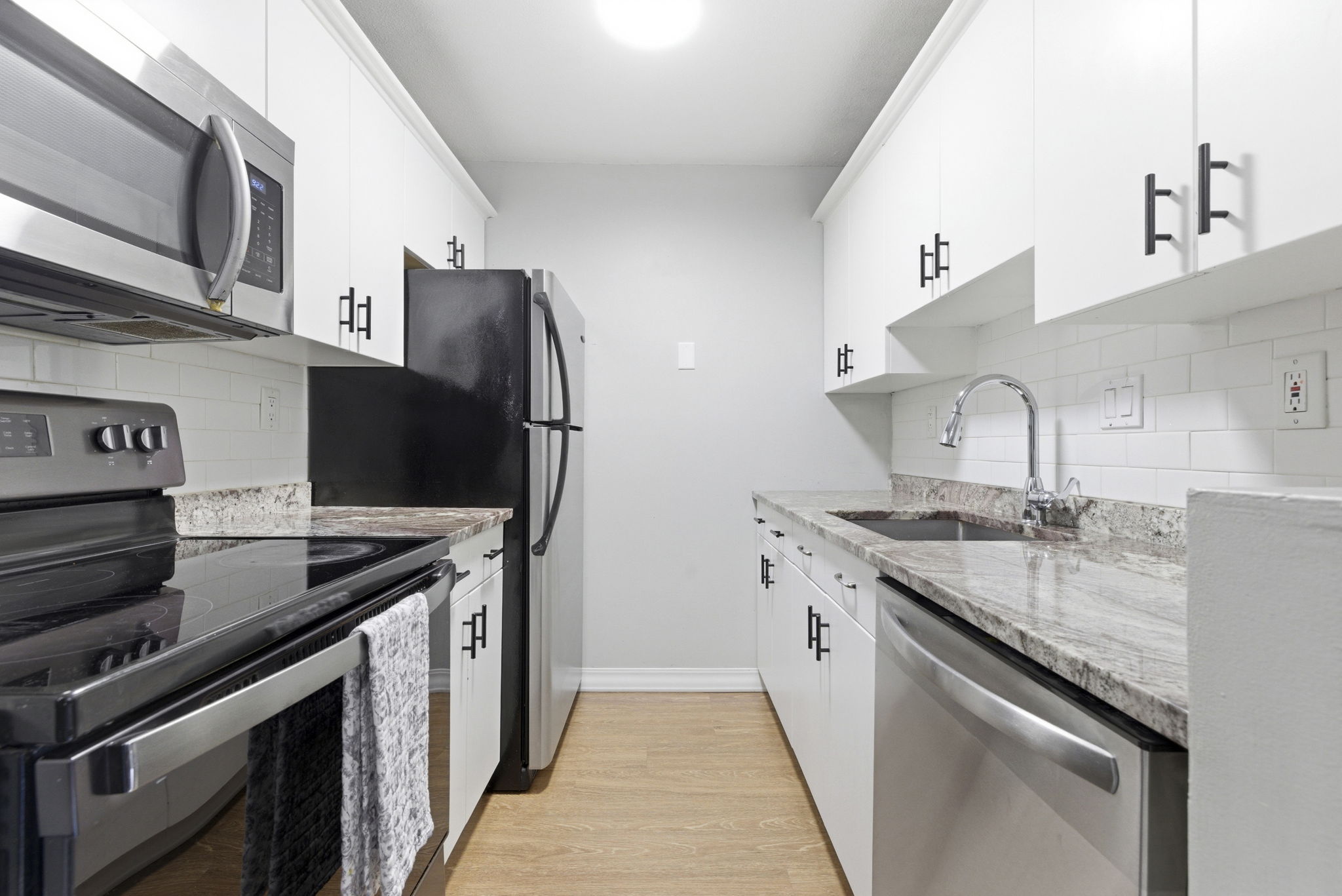 61 Wright Street, Unit 102 Stoneham, MA 02180 - Photo 8 of 26 a kitchen with stainless steel appliances granite countertop a sink stove and refrigerator