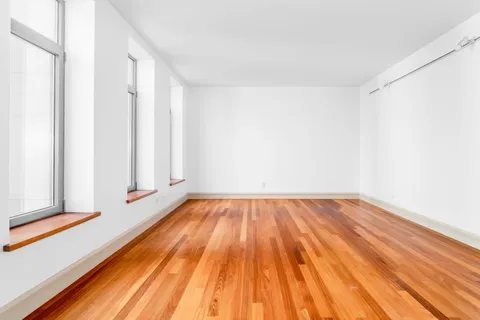 a view of a room with wooden floor and fence