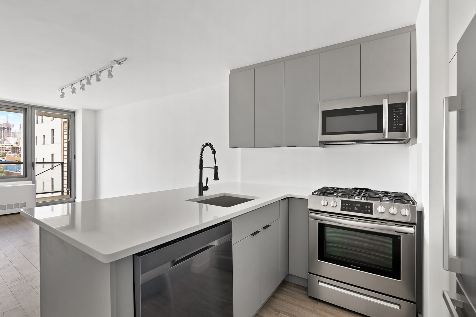 270 West 17th Street, Unit 9A Manhattan, NY 10011 - Photo 4 of 6 a kitchen with granite countertop a stove and a microwave