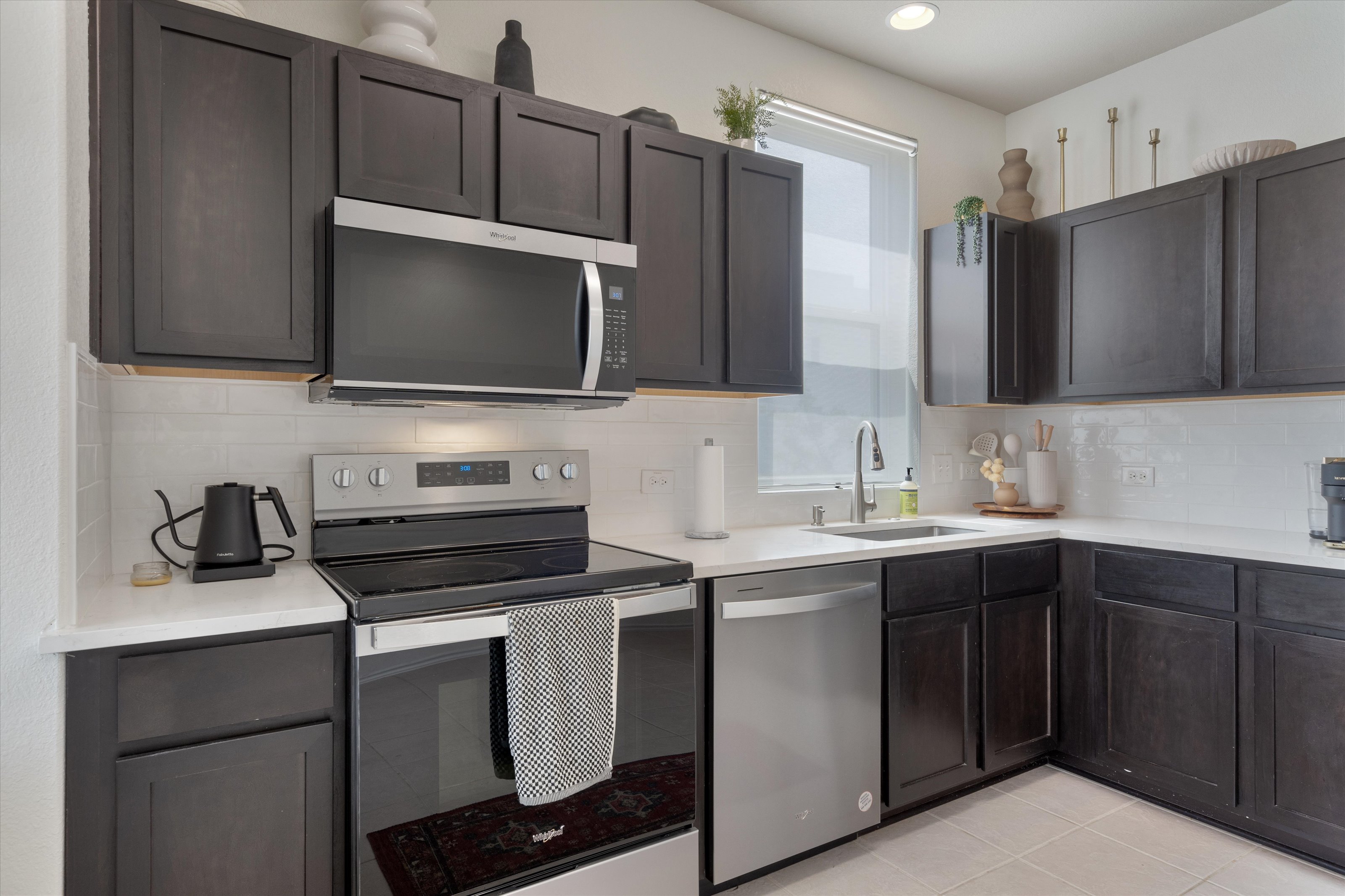 4330 Olenick Street Austin, TX 78723 - Photo 4 of 29 a kitchen with stainless steel appliances a sink cabinets and a microwave