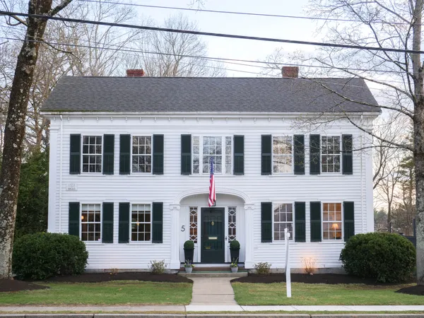 a front view of a house with a garden and plants