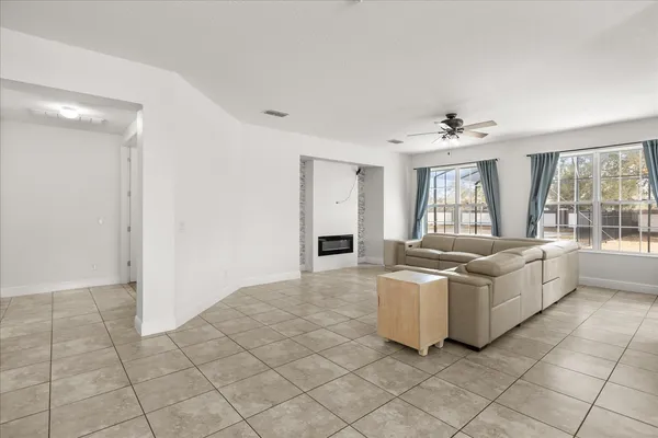 a living room with furniture and a large window with kitchen view