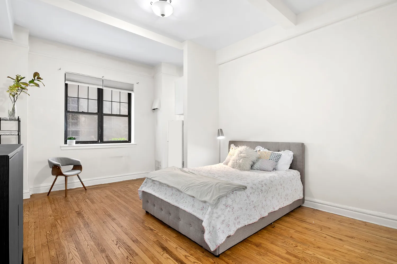 a bedroom with a bed and wooden floor