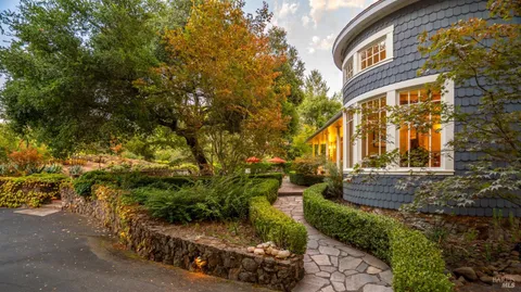 a view of a brick house with a yard and potted plants