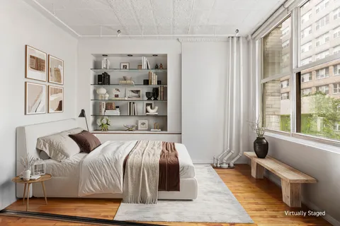 a bedroom with a bed couch and a window