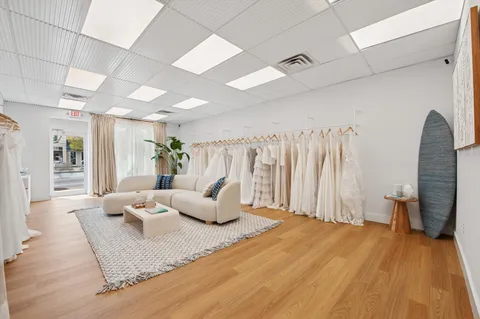 a living room with lots of furniture and view of kitchen