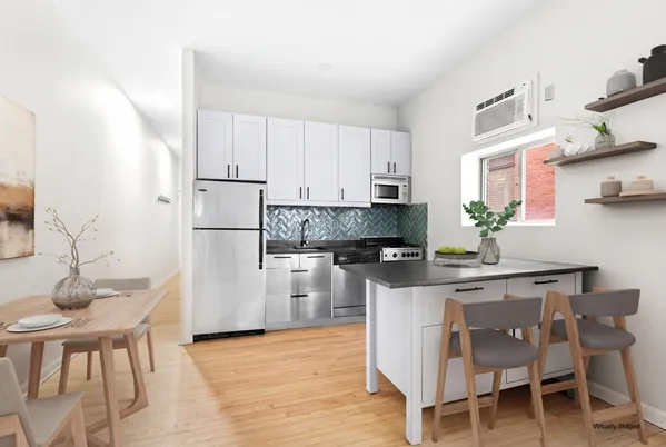 a kitchen with stainless steel appliances white cabinets and wooden floor
