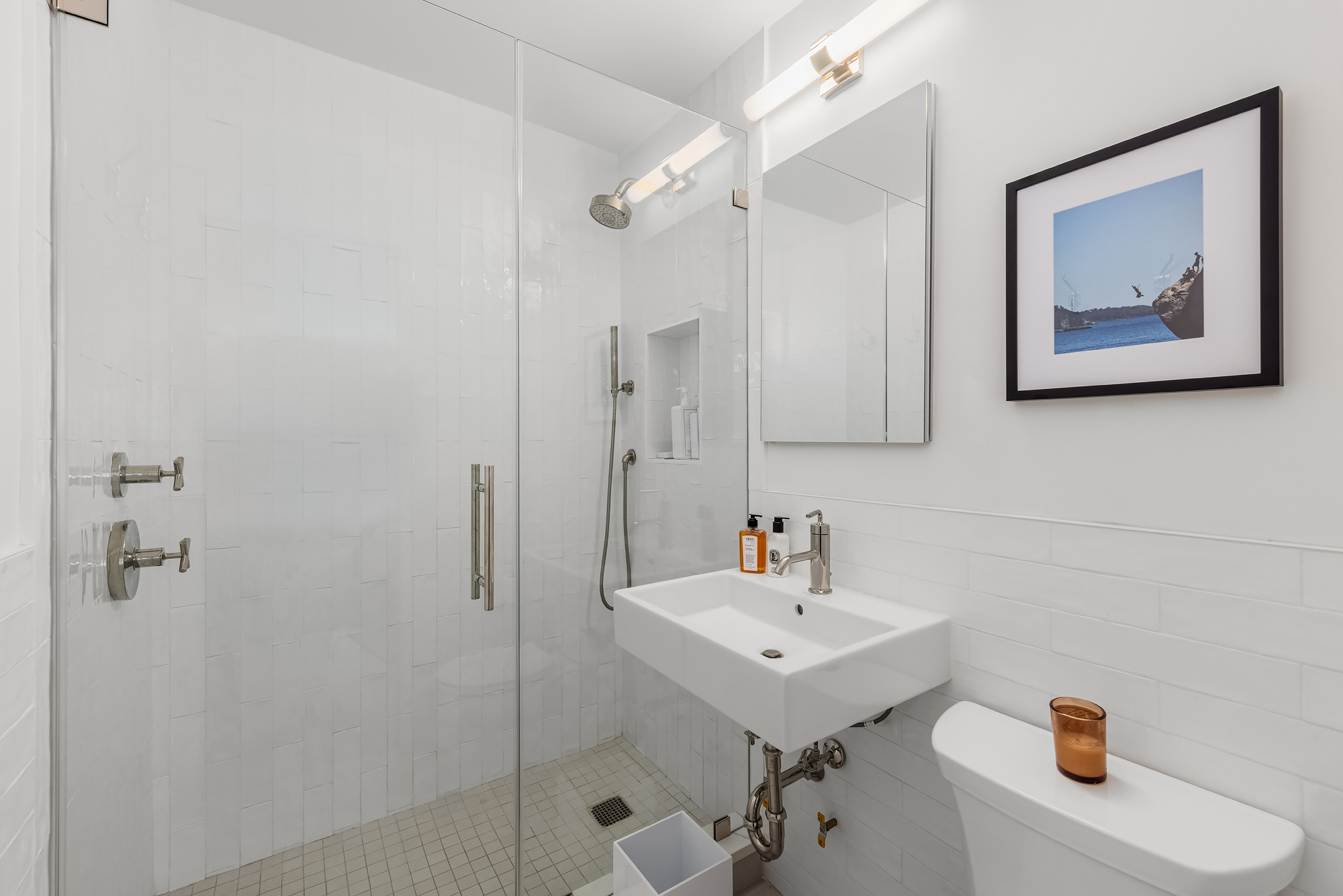 101 West 12th Street, Unit 12R Manhattan, NY 10011 - Photo 14 of 21 a bathroom with a sink a mirror and shower