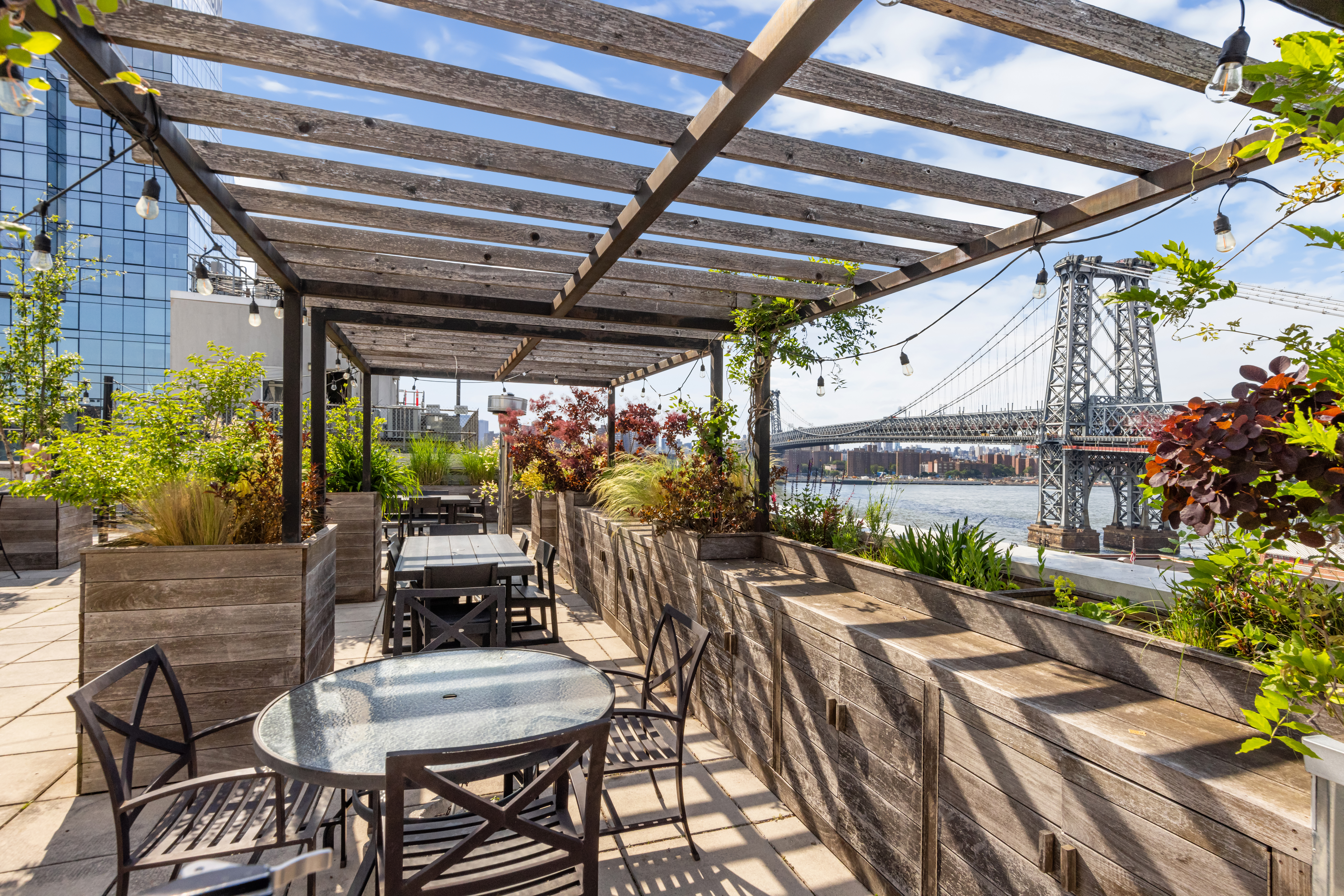 26 Broadway, Unit 402 Brooklyn, NY 11249 - Photo 12 of 17 a view of a patio with table and chairs potted plants with wooden floor