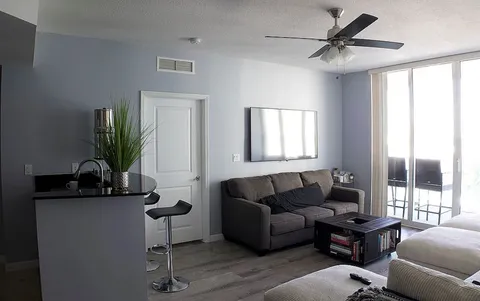 a living room with furniture a window and a flat screen tv
