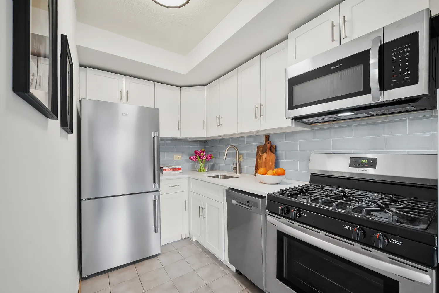 a kitchen with stainless steel appliances a refrigerator stove and white cabinets