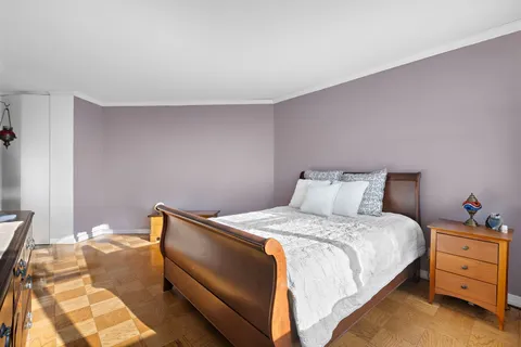 a bedroom with a bed and a lamp on the dresser