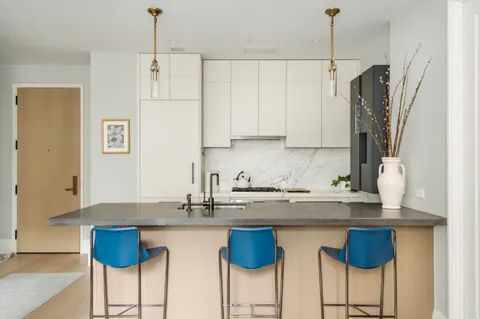a kitchen with stainless steel appliances granite countertop a white cabinets and a refrigerator
