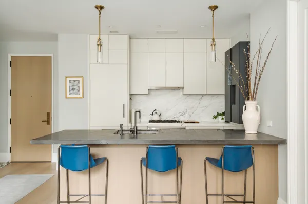 a kitchen with stainless steel appliances granite countertop a white cabinets and a refrigerator