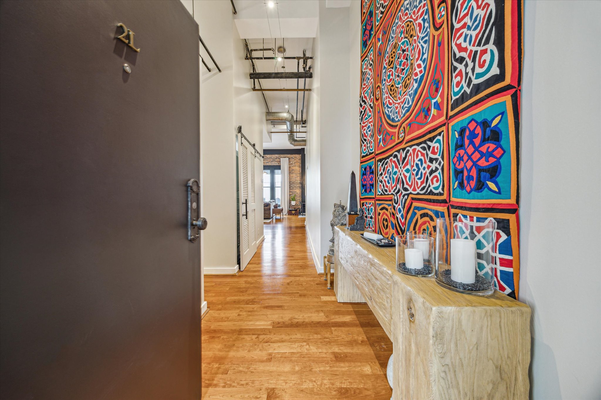 915 Franklin Street, Unit 2L 2L Houston, TX 77002 - Photo 2 of 11 a hallway with painting on the wall and a potted plant