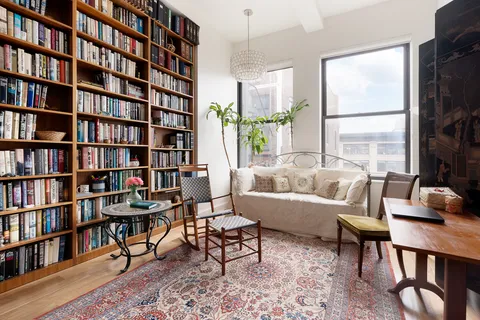 a living room with furniture and a book shelf
