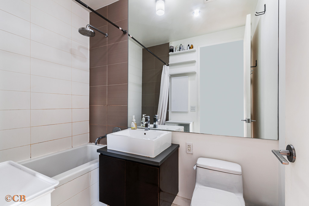 315 Gates Avenue, Unit 3H Brooklyn, NY 11216 - Photo 4 of 12 a bathroom with a sink toilet vanity and shower