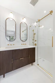 a bathroom with a double vanity sink toilet mirror and bathtub