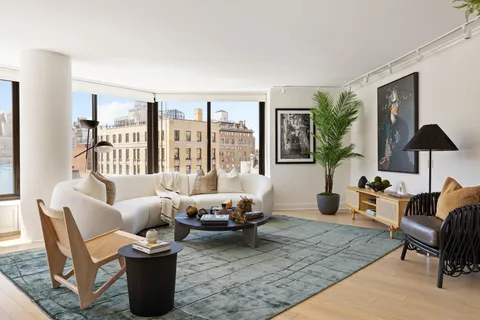 a living room with furniture large window and a table