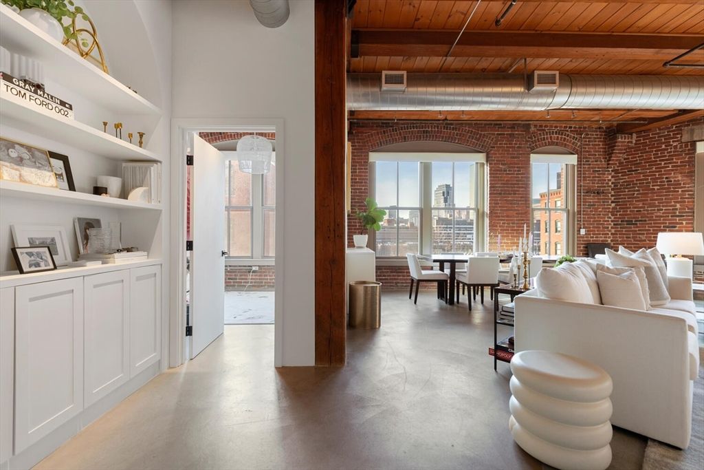 a living room with furniture and a dining table with wooden floor