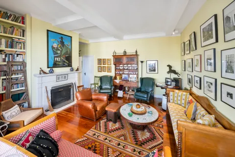 a living room with fireplace furniture and a book shelf