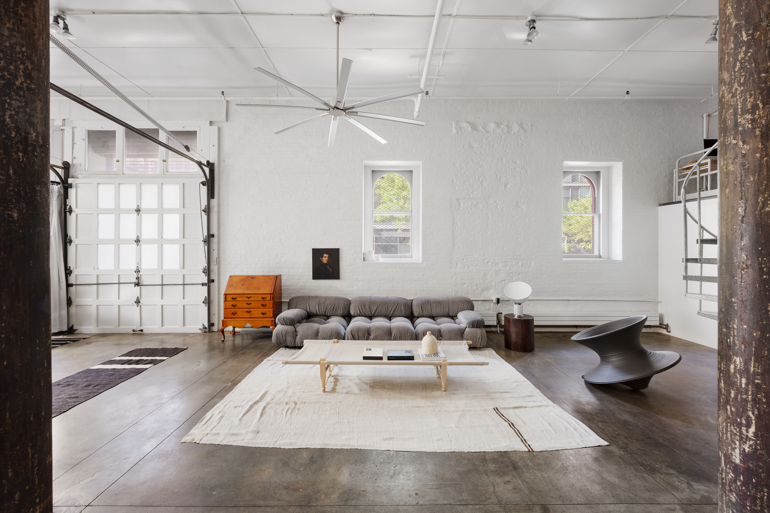 a living room with furniture gym equipment and a large window