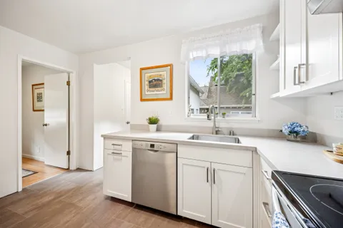 a kitchen with a sink cabinets and wooden floor