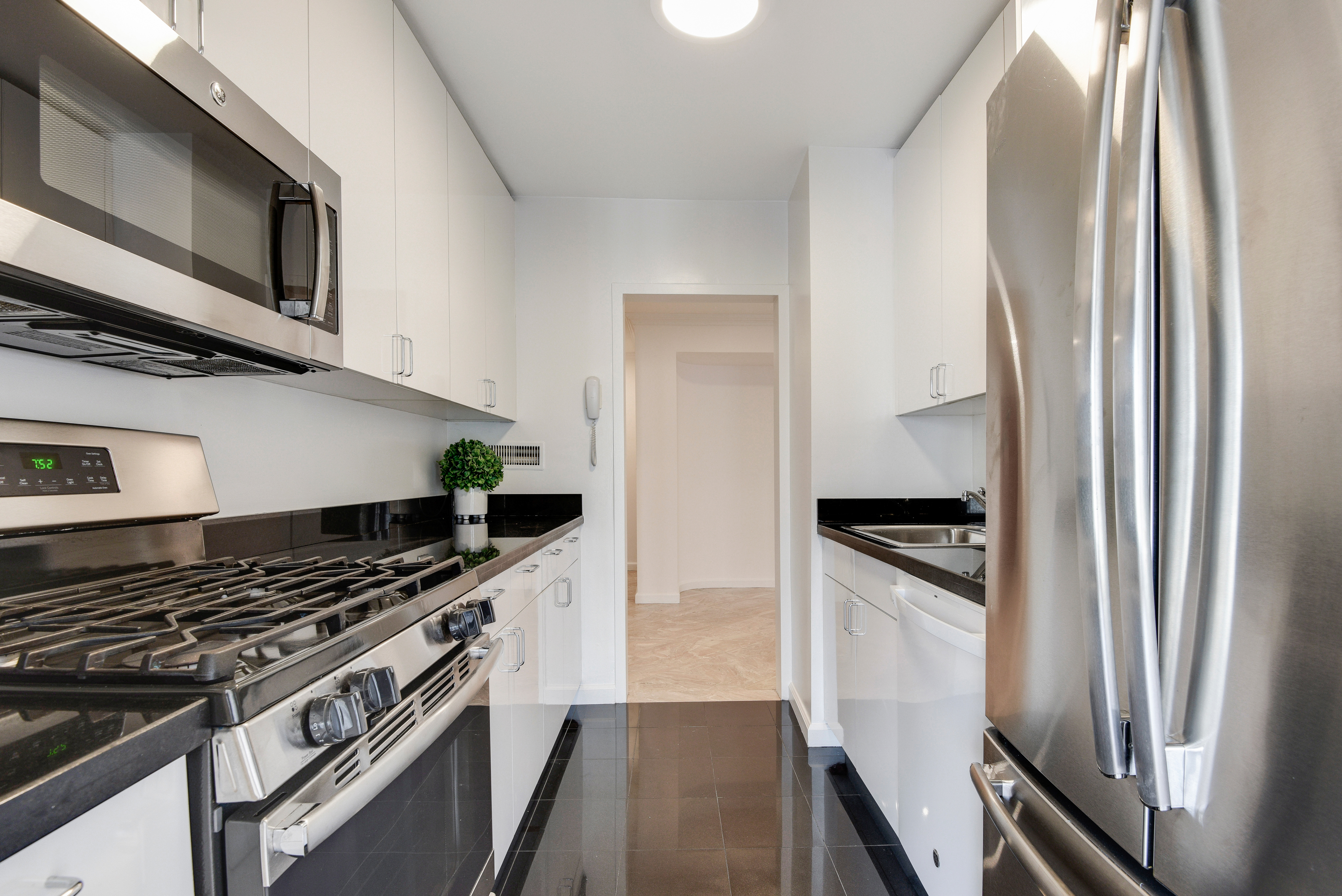 200 Central Park South, Unit 29C Manhattan, NY 10019 - Photo 8 of 23 a kitchen with stainless steel appliances granite countertop a stove and a refrigerator