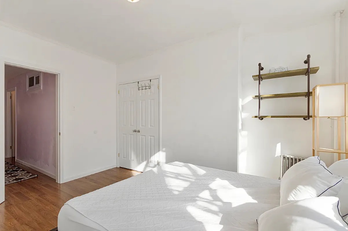 5-39 47th Road, Unit 2R Queens, NY 11101 - Photo 4 of 7 a bedroom with a bed and wooden floor