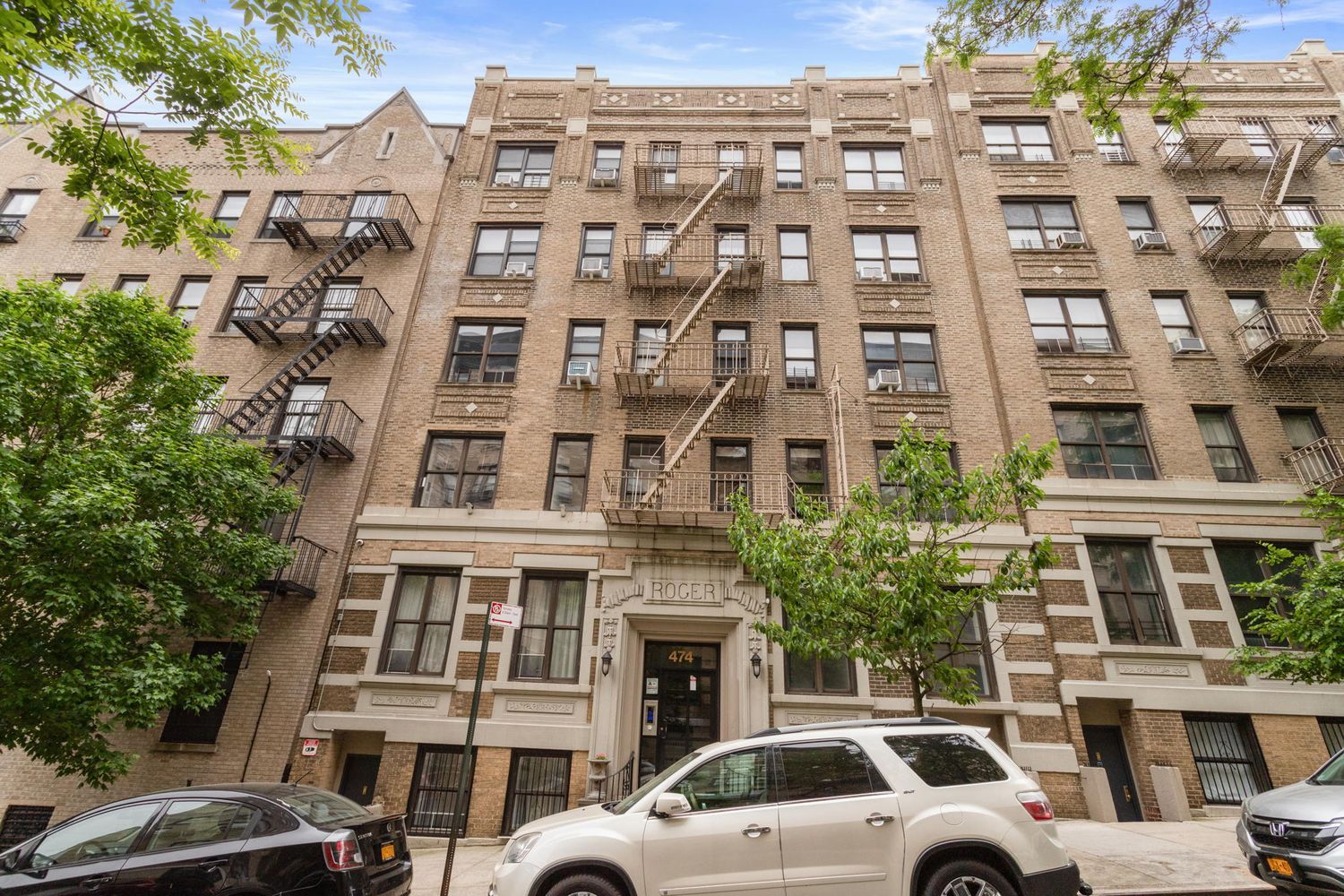 a view of a building with a yard and parking space
