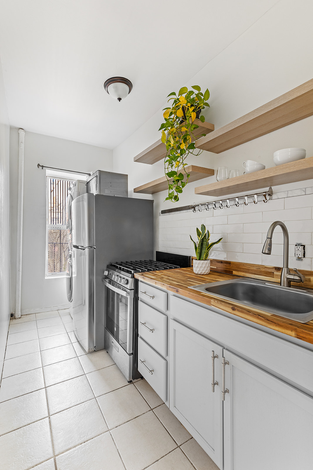 231 Vernon Avenue Brooklyn, NY 11206 - Photo 9 of 13 a kitchen with stainless steel appliances a sink cabinets and a window